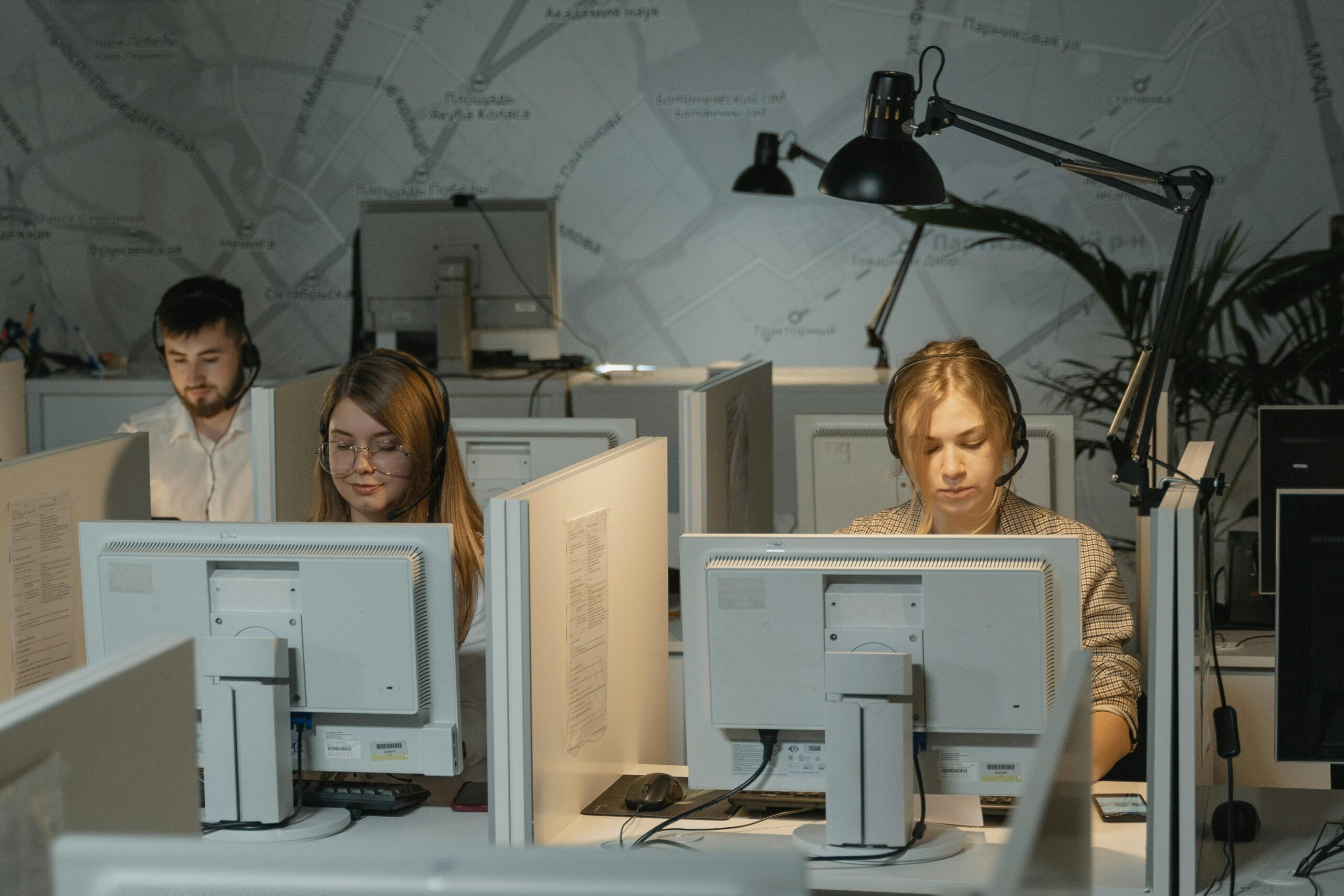 Call center agents working diligently with computers and headphones, providing customer support.